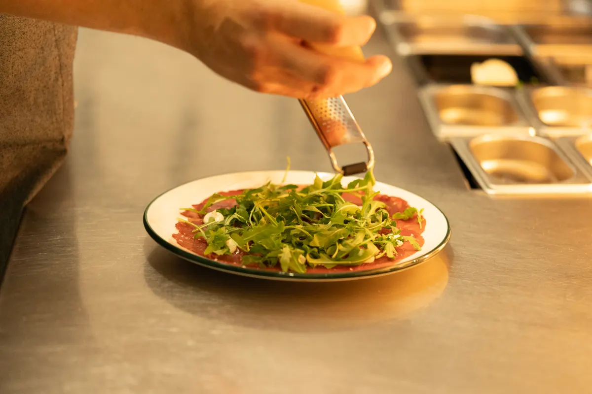 Beef carpaccio anrettes med rucola og parmesan i køkkenet